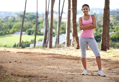 Buy stock photo A pretty young woman in sportswear exercising in the forest