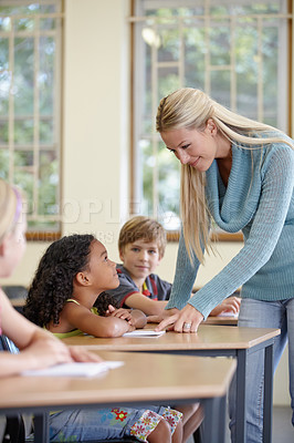 Buy stock photo Teacher, girl and students in classroom for education, learning and writing or language development with support. Happy woman and children for teaching, helping with knowledge and questions at school