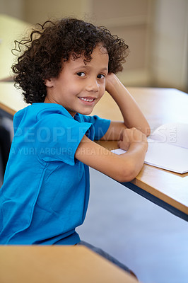 Buy stock photo Portrait, student and boy in a classroom, education and relax with a book, learning and creative. Face, studying or kid with joy, child development or desk with notes, teaching or knowledge in school