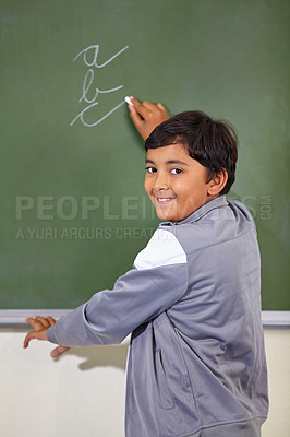 Buy stock photo Portrait, chalkboard and boy drawing, happy or child development with confidence, joy or art for learning. Academic, creative or kid student writing for practice in the classroom with face or cursive