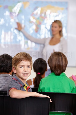 Buy stock photo Child, portrait and classroom with teacher for education, teaching and geography lesson or support in primary school. Face of a boy, kid or students for learning, map information and global knowledge