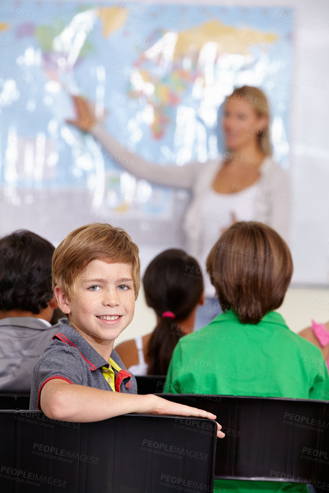 Buy stock photo Child, portrait and classroom with teacher for education, teaching and geography lesson or support in primary school. Face of a boy, kid or students for learning, map information and global knowledge