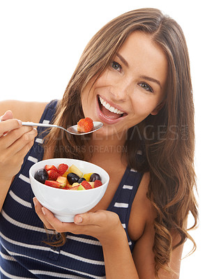 Buy stock photo A pretty young woman enjoying a bowl of fruit salad