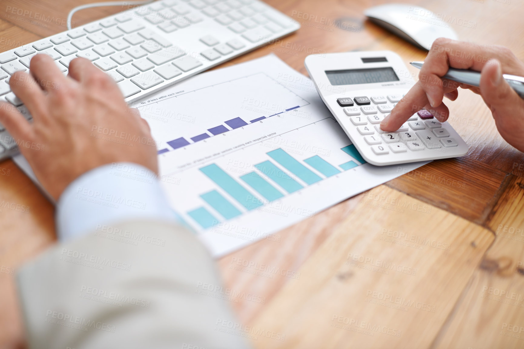 Buy stock photo Cropped shot of a businessman using a calculator at his work desk