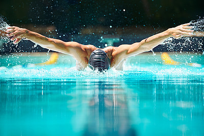 Buy stock photo Shot of a male swimmer doing the butterfly stroke toward the camera