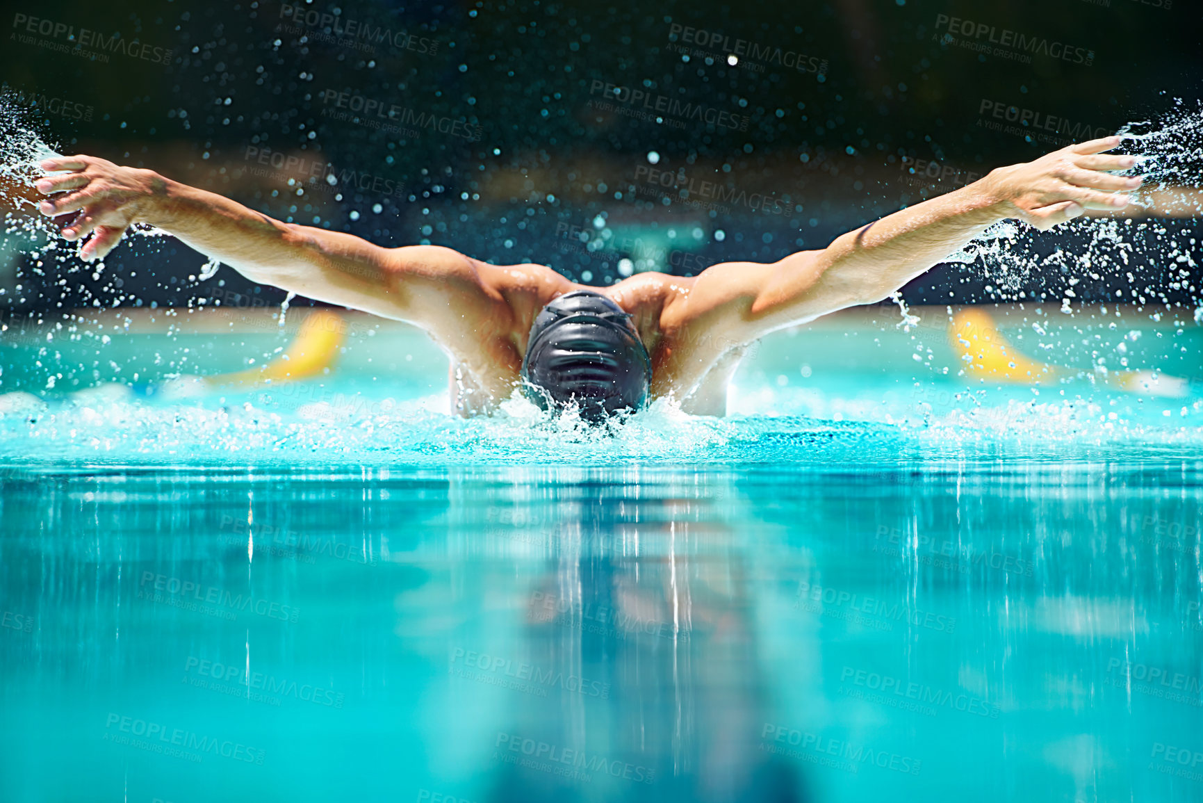 Buy stock photo Shot of a male swimmer doing the butterfly stroke toward the camera