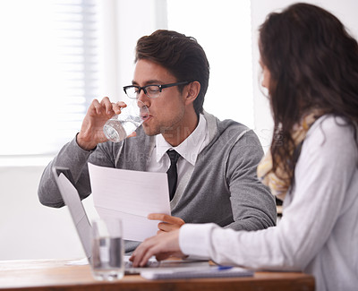 Buy stock photo A young man drinking water during an interview