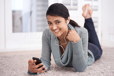 Buy stock photo Portrait of happy woman on floor with phone, earphones and relax with mobile app for podcast in house. Face of girl lying on carpet with smile, music and streaming service fon smartphone in home.