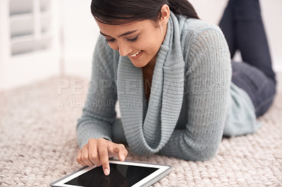 Buy stock photo Woman on carpet with tablet, smile and relax with studying, research and social media post in living room. Happy student girl on floor with digital app, elearning and reading blog online in home.