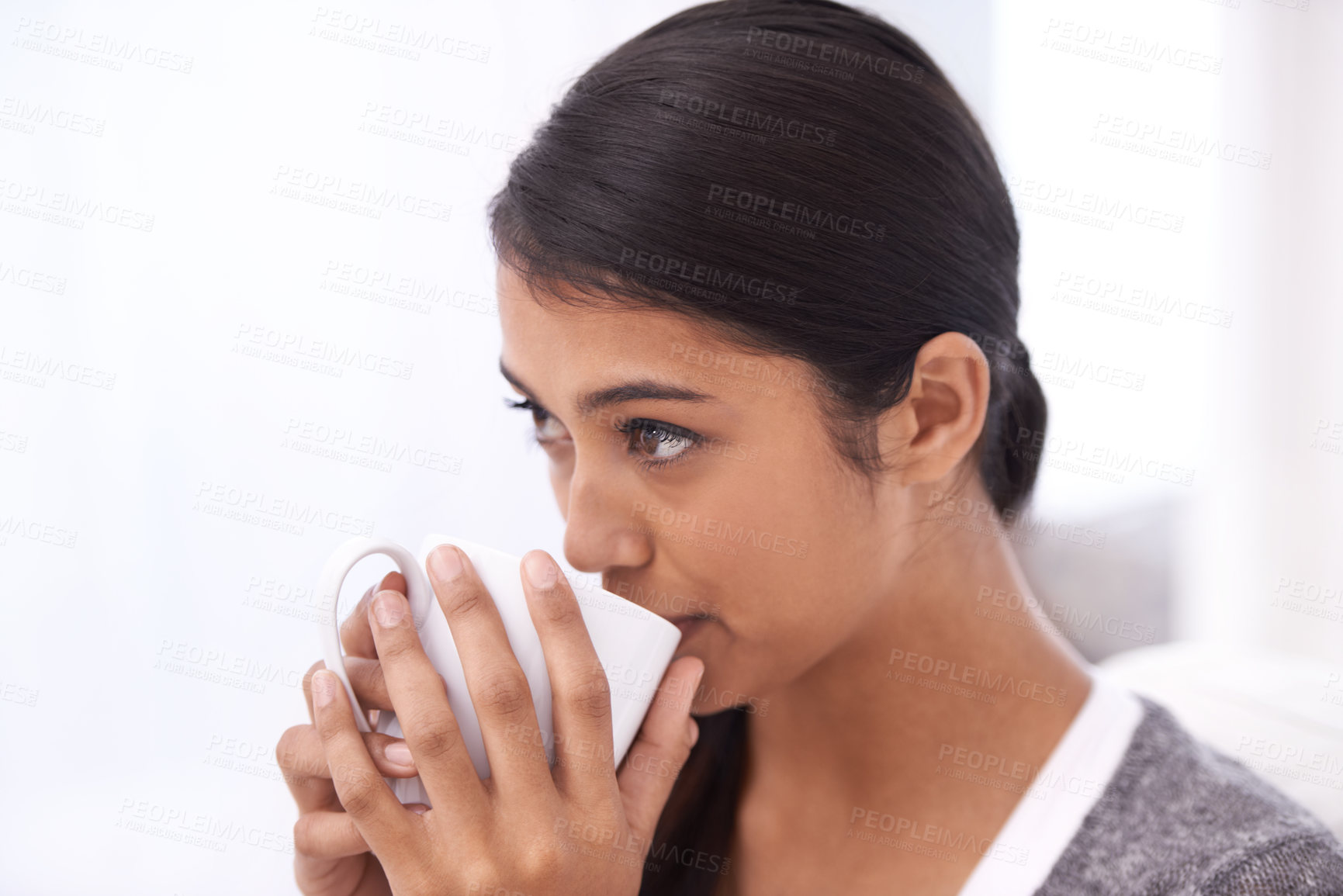 Buy stock photo Coffee, drinking and Indian woman on sofa for relax, comfortable and calm in home for wellness. Apartment, morning and person with mug on couch for hot beverage, tea and caffeine drink in living room