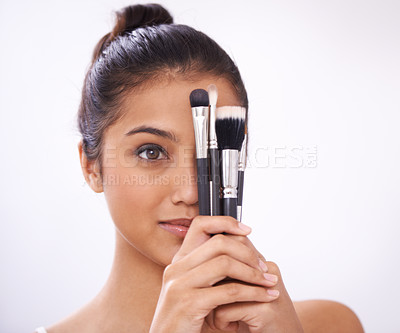 Buy stock photo Cosmetics, brushes and woman cover eyes in studio for beauty, foundation and makeup on a white background. Young model, artist or person with skincare, application tools or product for face coverage