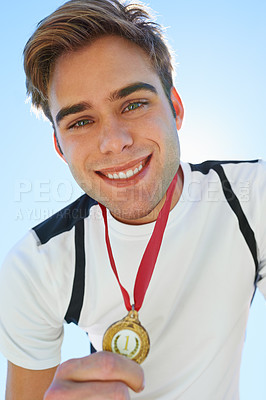 Buy stock photo Winner, athlete and sports medal for achievement, success and portrait in running competition. Happy face of a young runner or man with red and gold award for contest or marathon on a blue sky