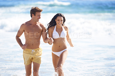Buy stock photo Happy couple, running on beach and summer bikini for holiday, support and love on vacation by ocean. Excited young woman and man holding hands in sea with water splash or waves for valentines day