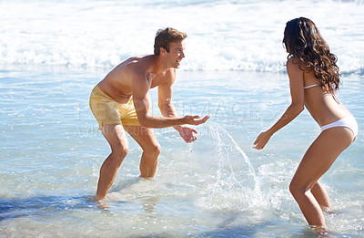 Buy stock photo Water, splash and happy couple playing on beach for holiday adventure together on tropical island nature. Love, man and woman on ocean vacation with playful fun, romance and smile on travel in Hawaii