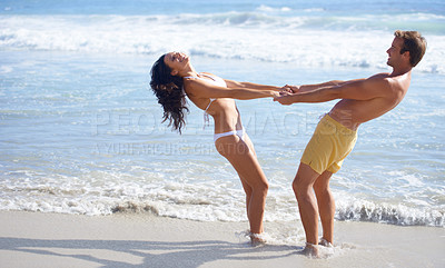 Buy stock photo Love, smile and playful couple on beach together for energy, vacation or honeymoon fun in summer. Travel, laughing or funny with young man and woman in water, sea or ocean for holiday bonding