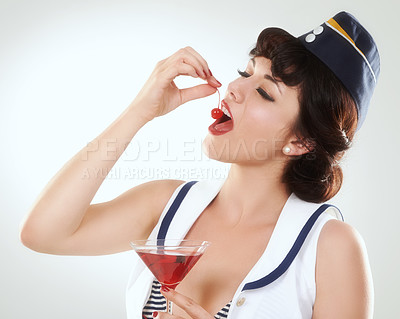 Buy stock photo Cocktail, stewardess and woman eating cherry in studio isolated on white background. Red martini, glass and air hostess enjoy alcohol fruit, vintage pin up girl or flight attendant travel on journey
