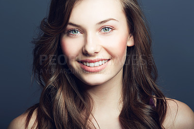 Buy stock photo Cosmetic, beauty and portrait of a woman in a studio with a natural, facial and skincare routine. Happy, smile and face of a young female model with makeup or dermatology treatment by blue background