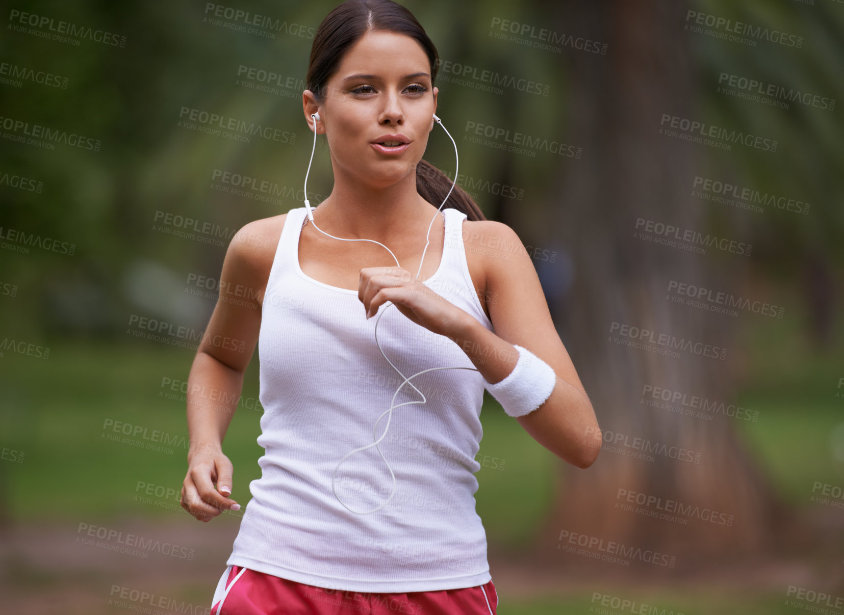Buy stock photo Music, runner and woman running in nature training, cardio exercise and endurance workout for wellness. Earphones, fitness or healthy sports athlete on jog on outdoors in forest with radio or podcast