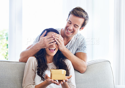 Buy stock photo A young boyfriend covering his girlfriend's eyes as he gives her a present