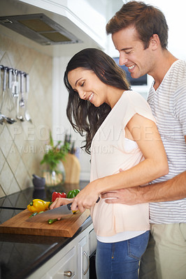 Buy stock photo Couple, embrace and cutting vegetables in kitchen, healthy meal and preparing food for eating at home. Happy people, love and bonding together in marriage, nutrition and hug for support and romance