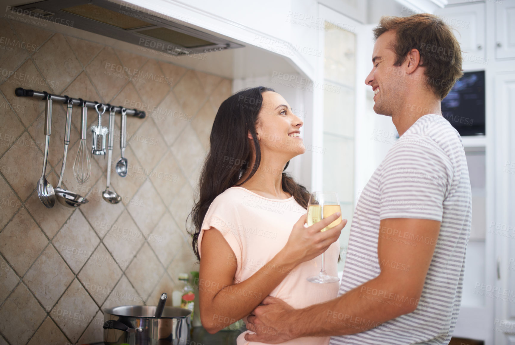 Buy stock photo Couple, hug and wine for cooking in kitchen, healthy meal and preparing food for eating at home. Happy people, alcohol and bonding together in marriage, nutrition and embrace for support and romance