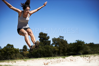 Buy stock photo Woman, sand and long jump athlete training for workout endurance competition, skill or performance. Female person, face and fitness goal for cardio achievement practice or leap run, wellness or sport