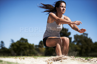 Buy stock photo A young woman doing long jump