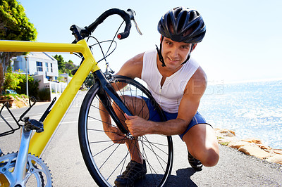 Buy stock photo Man, portrait and wheel repair on road for safe cycling transport, performance or puncture. Male person, tyre and ocean for gear improvement or endurance for triathlon training, sport or practice