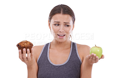 Buy stock photo Confused, woman and choice of healthy food in hands with apple and muffin in white background of studio. Mockup, space and person balance a decision in nutrition with sweets, dessert and fruit