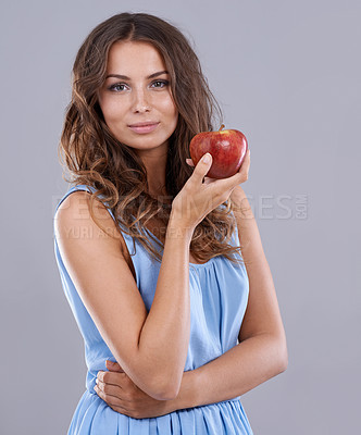 Buy stock photo Happy woman, portrait and red apple for natural nutrition, diet or healthy snack on a gray studio background. Face of female person, brunette or model smile with organic fruit for health and wellness