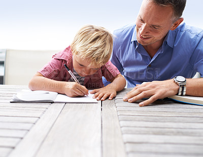 Buy stock photo Writing, learning and dad with son at table in backyard for child development, knowledge and studying. Education, books and help, father and kid on patio with notebook, homework project and drawing.