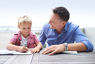 Buy stock photo Homework, learning and dad with son at table in backyard for child development, knowledge and studying. Education, books and help, happy father and kid on patio with notebook, writing and drawing.
