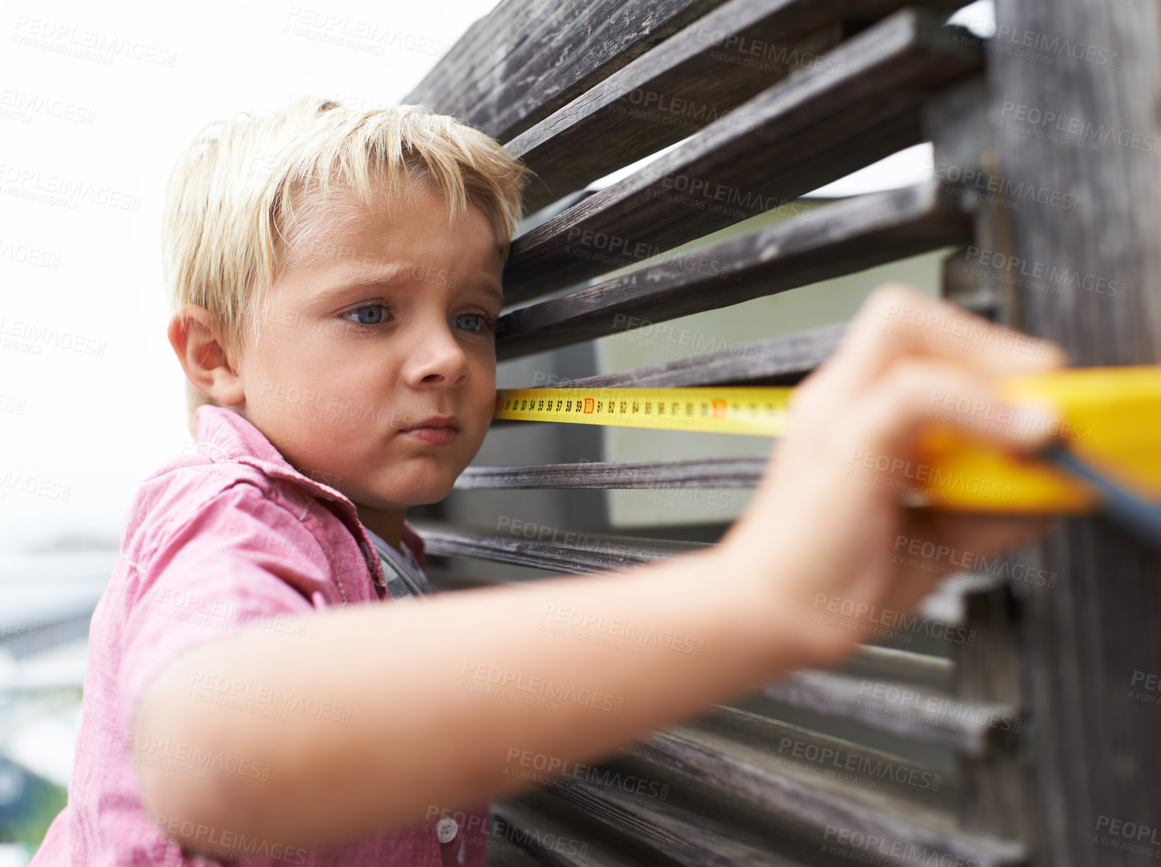 Buy stock photo Focus, measuring tape and young child doing maintenance on wood gate for fun or learning. Serious, equipment and little boy kid working on repairs with tool for home improvement outdoor at house.