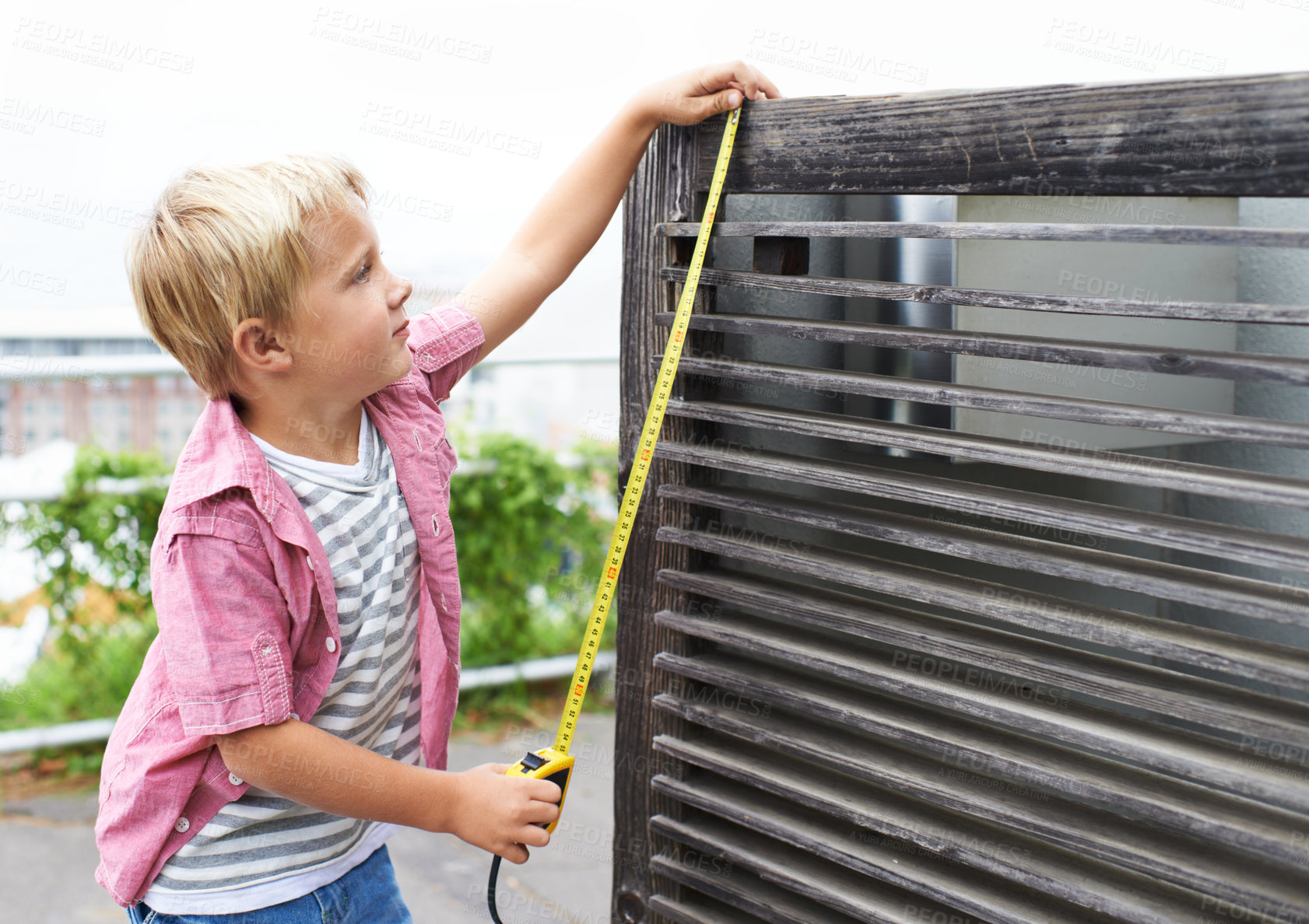 Buy stock photo Cute, measuring tape and portrait child doing maintenance on wood gate for fun or learning. Happy, equipment and young boy kid working on repairs with tool for home improvement outdoor at house.