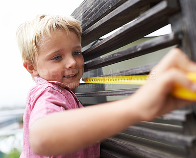 Buy stock photo Smile, measuring tape and boy kid doing maintenance on wood gate for fun or learning. Happy, equipment and young child working on handyman repairs with tool for home improvement outdoor at house.