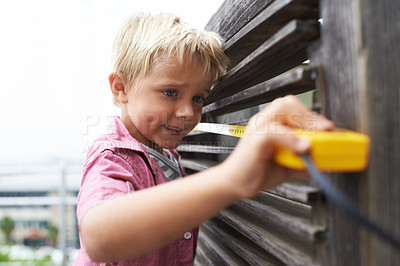 Buy stock photo Happy, measuring tape and young child doing maintenance on wood gate for fun or learning. Smile, equipment and cute boy kid working on repairs with tool for home improvement outdoor at house.