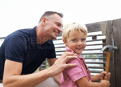 Buy stock photo A handsome father teaching his son how to use a hammer