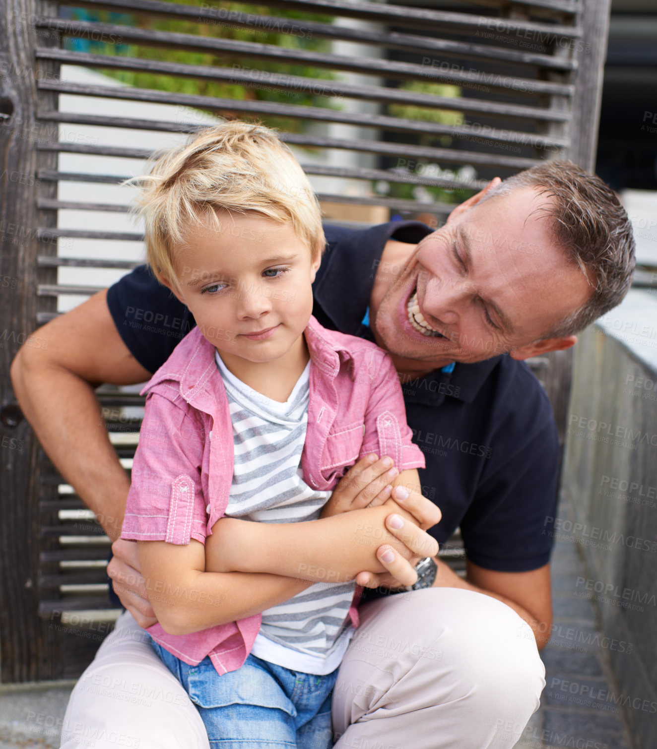 Buy stock photo Laughing, happy and father tickling child for bonding together in backyard at family home. Smile, annoyed and dad playing and having fun with bored boy kid by wood gate for quality time outdoor house