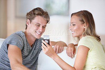 Buy stock photo Phone, search and happy couple on a sofa checking web, planning or booking discussion at home with holiday choice. Smartphone, streaming and people in a living room with love, conversation or scroll