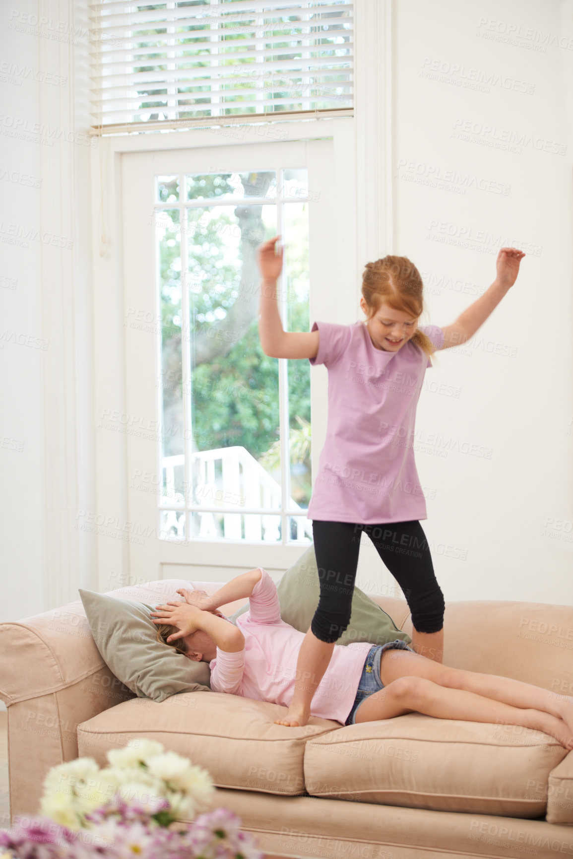 Buy stock photo Girl children, sisters and playing on couch, fun and jump on sofa with energy, bonding and love at family home. Friends, playful and time together in living room, happiness and excited for friendship