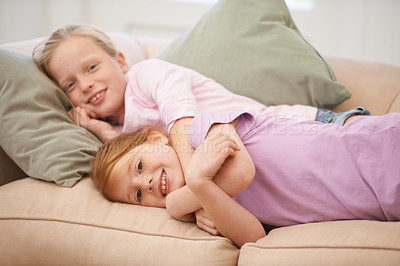 Buy stock photo Children, portrait and girl siblings on a sofa with love, hug and trust at home together. Family, kids and sisters embrace while lying in a living room with support, safety or bonding on the weekend