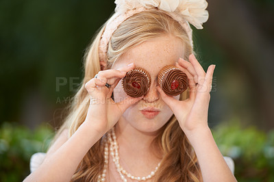 Buy stock photo Child, cupcakes and eyes for fun play or dress up in garden for birthday celebration, dessert or event. Female person, fancy accessories and funny face with sweet food or outdoor, quirky or humor