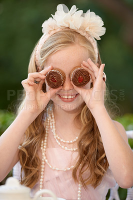 Buy stock photo Child, cupcakes and eyes or play smile or dress up in garden for birthday celebration, dessert or event. Female person, fancy accessories and funny face with sweet food or outdoor, quirky or humor