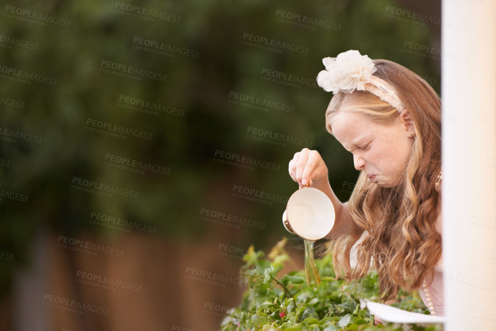 Buy stock photo Child, tea and pouring or disgust in garden for gross taste at party event or unhappy, drink or disappointed. Female person, girl and cup or warm beverage fail for strong flavour, outdoor or backyard