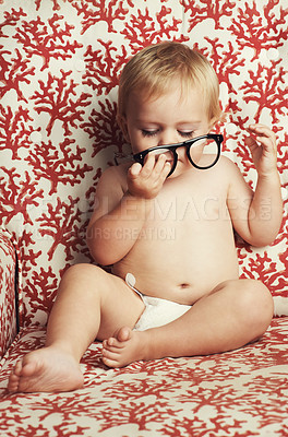 Buy stock photo Glasses, playing and sweet baby in a studio with vision, health or eye care accessory for development. Cute, eyewear and young child, infant or toddler kid with spectacles by wallpaper background.