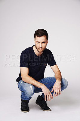 Buy stock photo Portrait of a handsome young man crouching in studio