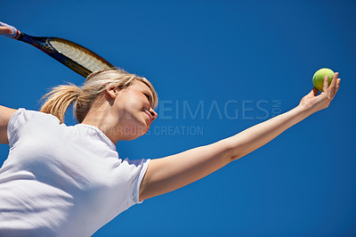 Buy stock photo A young tennis player serving during a match