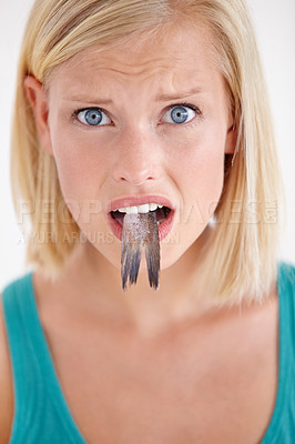 Buy stock photo Confused, woman and portrait eating fish, tail and surprise on white background of studio. Crazy, diet and person with doubt in weird seafood, cuisine and taste gross or strange food in mouth