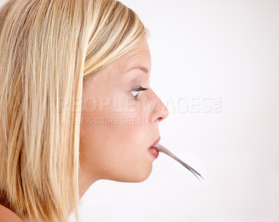 Buy stock photo Woman, surprise and eating a fish in mouth with strange food or tail on lips in white background or mockup. Crazy, diet and person with weird seafood, cuisine and disgust for taste of tuna or salmon