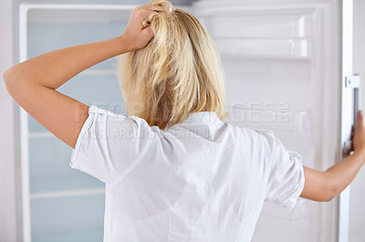 Buy stock photo Rearview of a young woman looking in her empty fridge